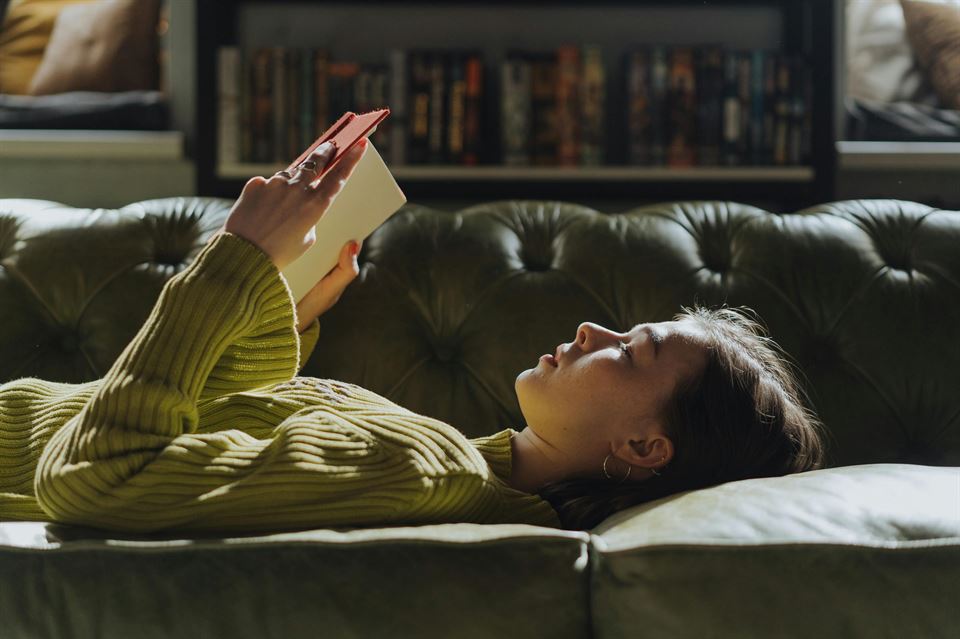 mujer-lee-libro-tumbada-sofa