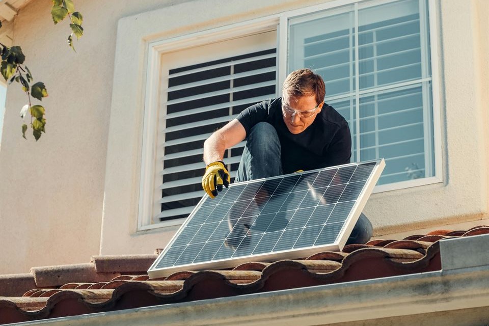 hombre-coloca-panel-solar-techo-vivienda